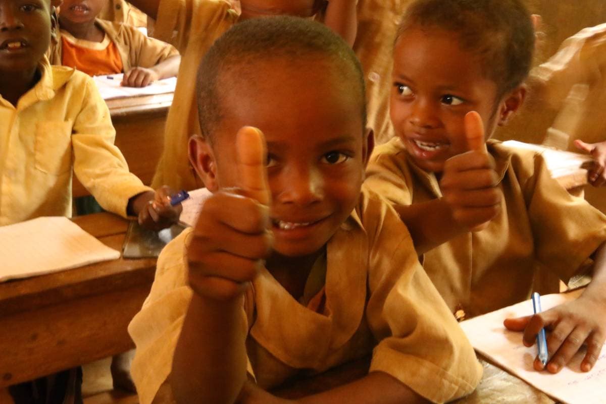 Écoliers souriants levant les pouces
